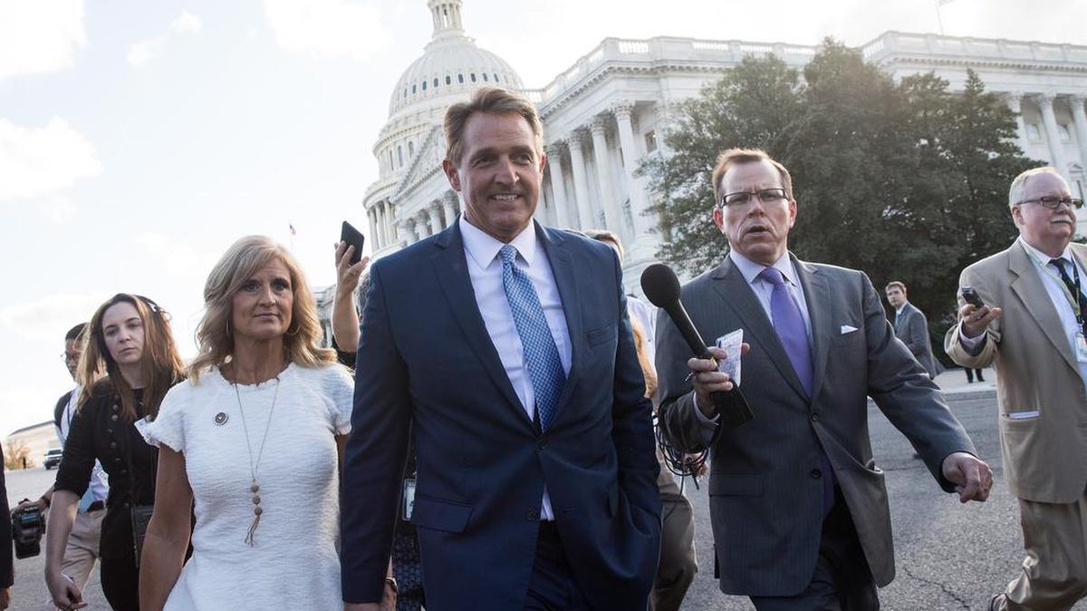 El senador Jeff Flake (R-AZ) y su esposa Cheryl Flake abandonan el Capitolio mientras los periodistas los siguen, el 24 de octubre de 2017 en Washington, DC.