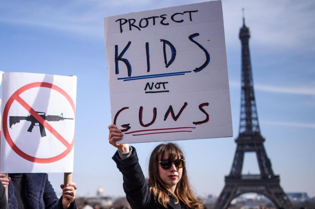 Una mujer protesta cerca de la emblemáticaTorre Eiffel en apoyo al movimiento de la “Marcha por Nuestras Vidas” desde París, el 24 de marzo de 2018.