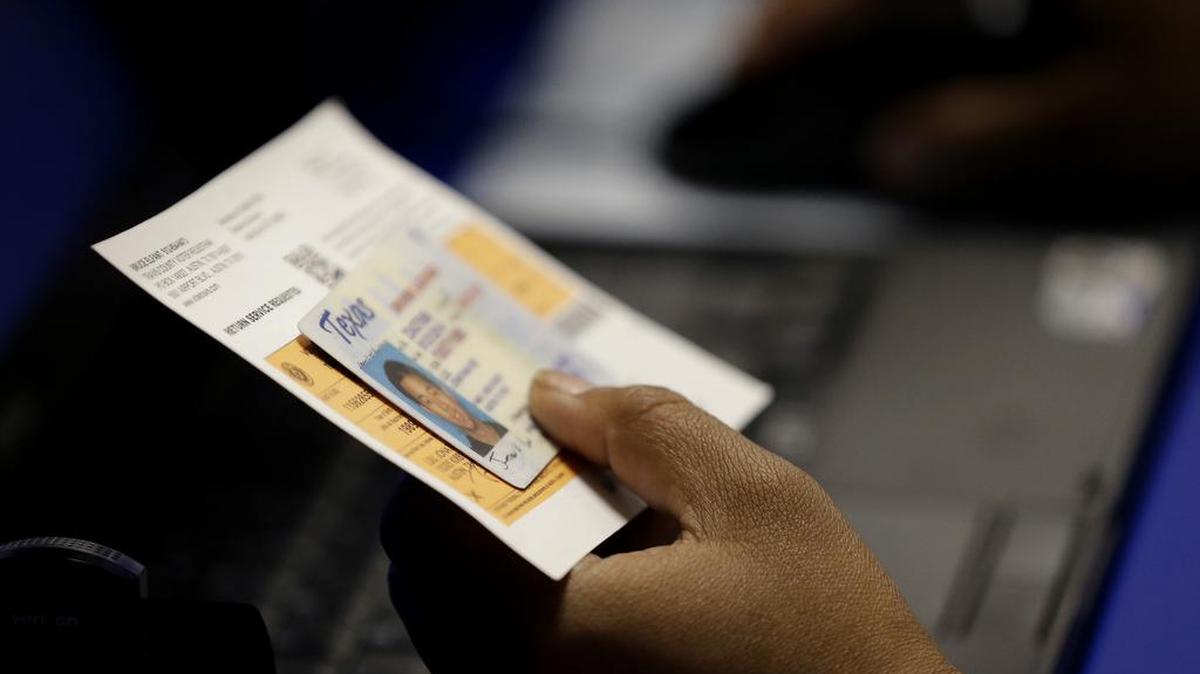 Un funcionario electoral revisa la identificación de un votante, el 26 de febrero de 2014, en Austin, Texas.