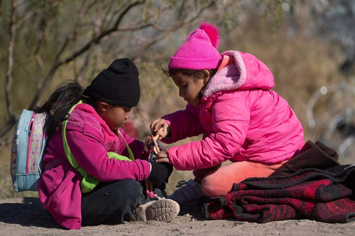 Niños migrantes juegan en la orilla sur del Río Grande el 18 de diciembre de 2024 después de que los migrantes cruzaron la frontera internacional.