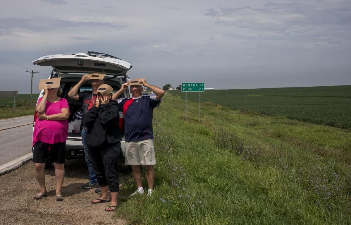 Sonja Hanrahan, John y Madelyn Riles y Joe Hanrahan de Humboldt, Iowa, observan desde el lado de la autopista 67 el eclipse solar el lunes 21 de agosto de 2017, cerca de Verdon, Nebraska.