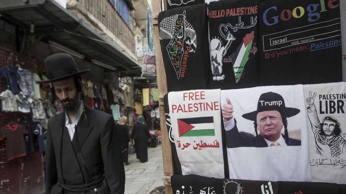 Un judío ultra ortodoxo pasea delante de una tienda con camisetas con la imagen del presidente de EEUU, Donald Trump, en el antiguo casco de Jerusalén, Israel, el 18 de mayo de 2017. Donald Trump visitará Israel y Belén la próxima semana.