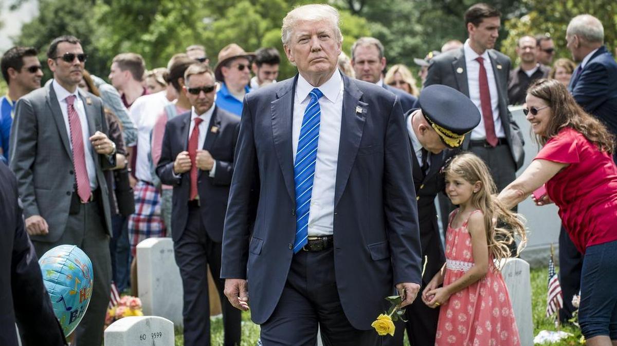 El presidente estadounidense, Donald Trump (c), participa en una ofrenda floral como homenaje a los militares fallecidos en combate con motivo del Día de los Caídos el lunes 29 de mayo de 2017, en el cementerio Nacional de Arlington, Virginia (Estados Unidos).