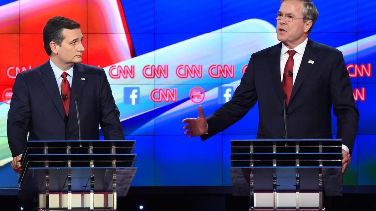 El candidato presidencial republicano, el ex gobernador de Florida, Jeb Bush (der.) habla mientras Ted Cruz lo observa durante el debate presidencial organizado por CNN, en The Venetian Las Vegas el 15 de diciembre, 2015, en Las Vegas, Nevada.