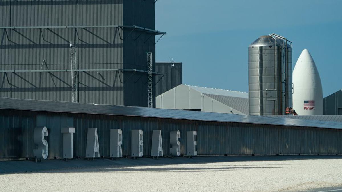 La entrada a las instalaciones de producción de Starship de SpaceX se ve cerca de Brownsville, Texas, el 22 de julio de 2021. SpaceX ha cambiado el nombre del área Starbase y al fondo se ve una maqueta del hardware de la NASA para el sistema de aterrizaje humano del programa Artemis.