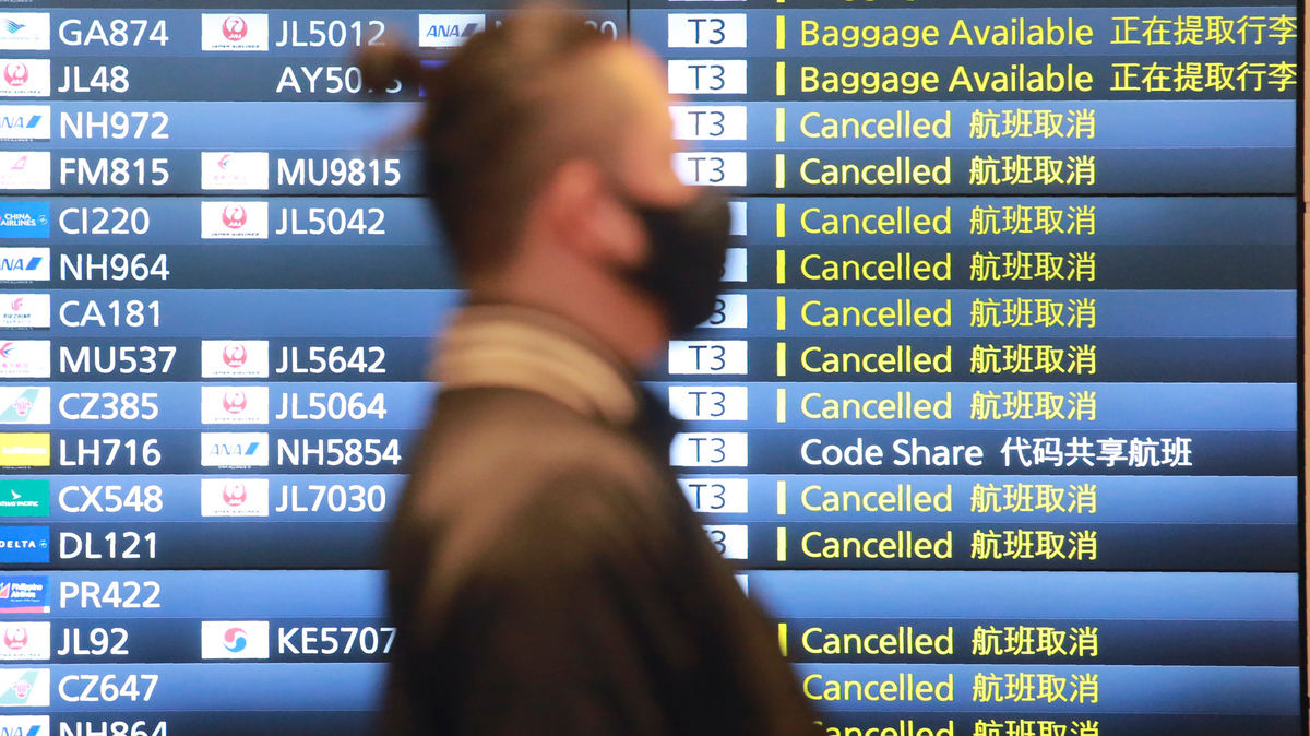 ARCHIVO _ Un hombre camina junto a una pizarra de información en el aeropuerto internacional Haneda en Tokio el 28 de diciembre del 2020. Japón anunció que comenzará a aflojar las restricciones a partir del 8 de noviembre del 2021 para viajeros plenamente vacunados, excluyendo turistas, en respuesta a pedidos de la comunidad de negocios luego de una declinación rápida de las infecciones con coronavirus. (AP Foto/Koji Sasahara)