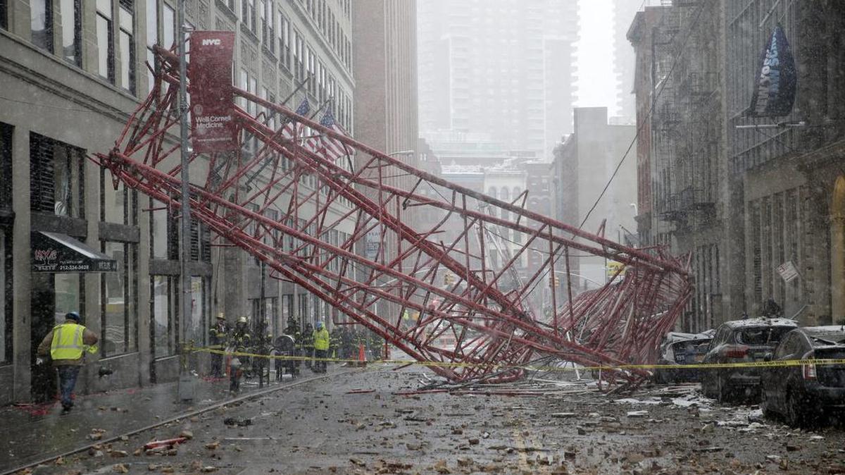 Varios bomberos observan el lugar donde ha caído una grúa colocada a una altura de veinte pisos en el barrio de Tribeca, en la parte sur de la isla de Manhattan, Nueva York, Estados Unidos hoy 5 de febrero de 2016.