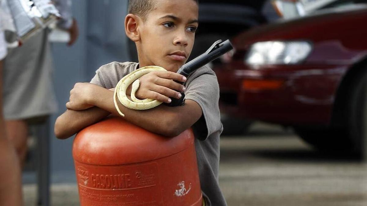 Francisco Martínez, de 9 años y alumno de la escuela José Facundo Cintrón, espera el lunes para comprar gasolina con su familia en Yabucoa, Puerto Rico.