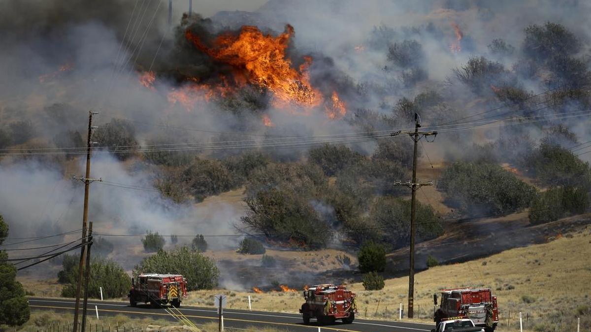 Camiones de bomberos corren por la Carretera 178 cercana a la localidad de Lake Isabella, el viernes, a medida que el fuego se extiende por el área.
