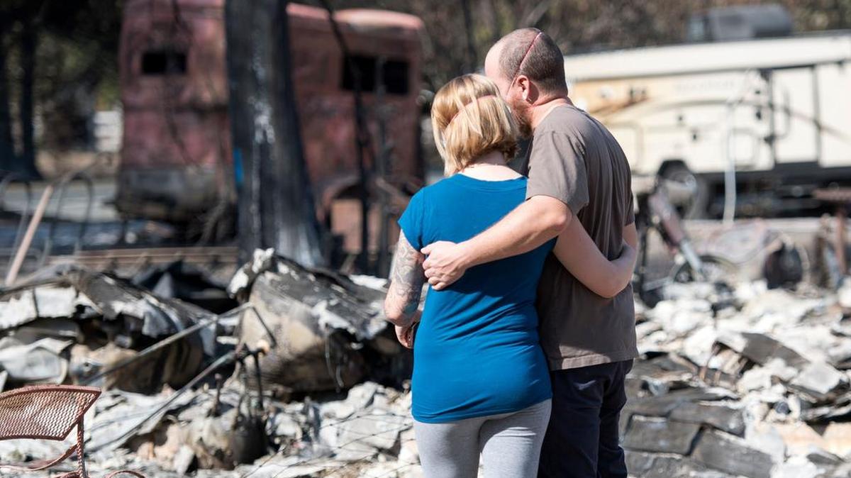 Una pareja contempla su casa destruida por los incendios en el Redwood Valley, California.