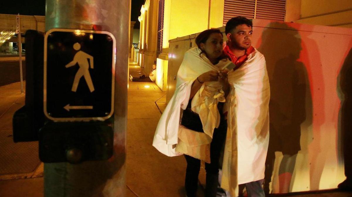Varias personas permanecen a la entrada del hotel Mandalay Bay el lunes 2 de octubre de 2017, cerca del lugar donde se produjo un tiroteo indiscriminado la pasada noche en Las Vegas.