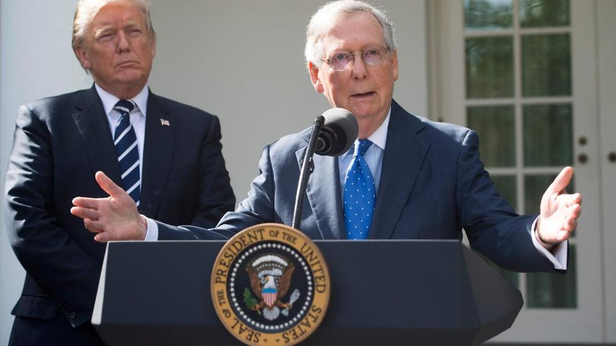 El presidente de EEUU, Donald Trump, escucha al líder mayoritario del Senado Mitch McConnell habla con los medios de prensa en el Rose Garden de la Casa Blanca en Washington, DC, el 16 de octubre de 2017.