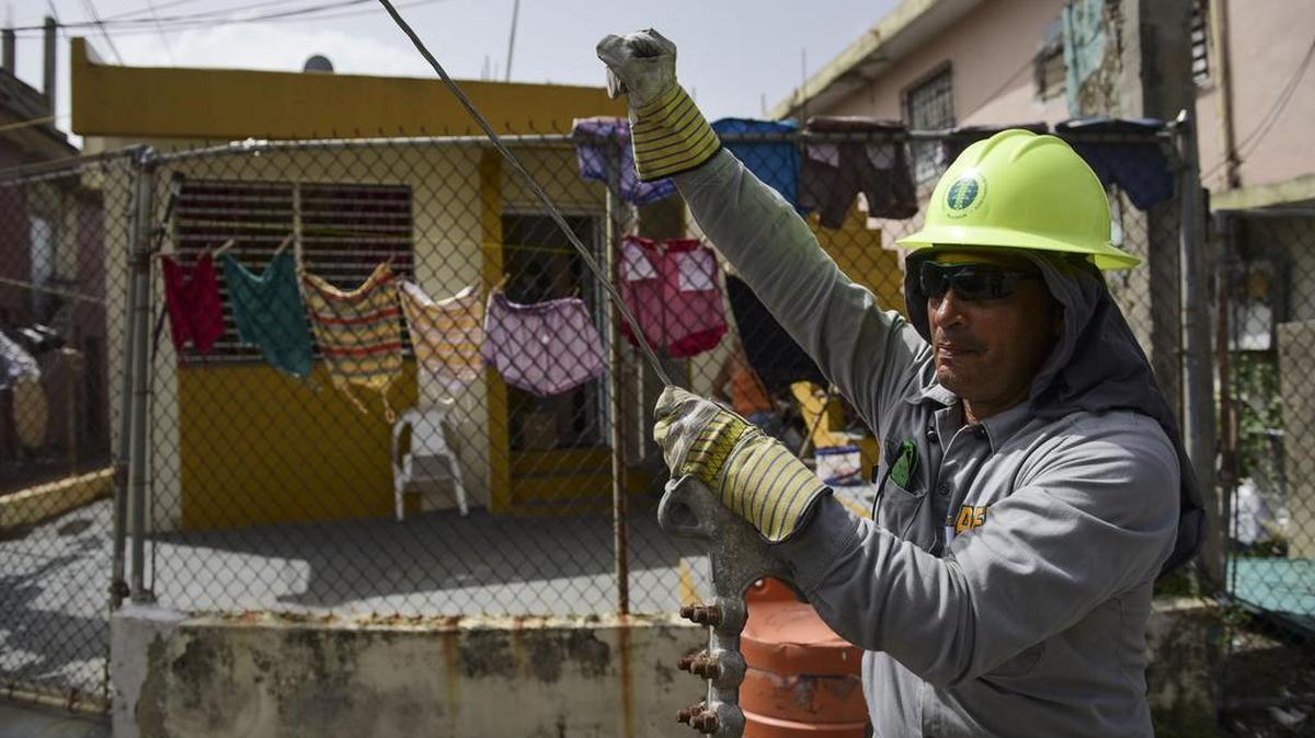 En esta foto del jueves 19 de octubre de 2017, Ezequiel Rivera trabaja con la Autoridad de Energía Eléctrica para restaurar las líneas de distribución dañadas por el huracán María en la comunidad de Cantera en San Juan, Puerto Rico.