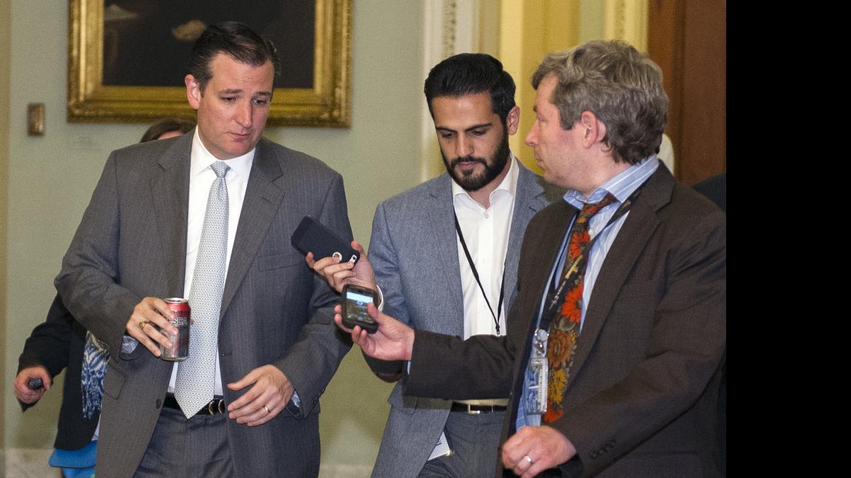 
El senador Ted Cruz (izq.), habla con los reporteros al llegar a la sesión especial del Senado el domingo.
