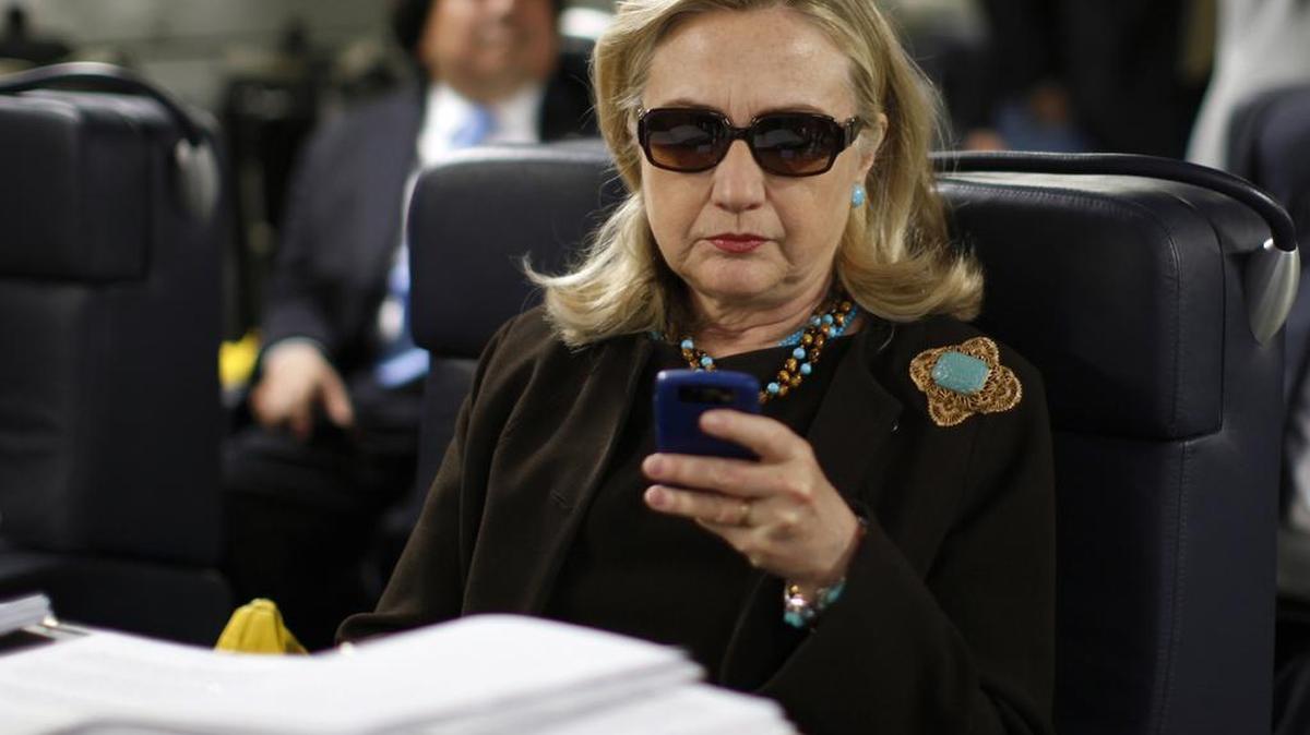 Foto de archivo de 18 de octubre de 2011. La entonces secretaria de Estado Hillary Rodham Clinton revisa su Blackberry desde un escritorio dentro de un avión militar C-17 a partir de su salida de Malta, en el mar Mediterráneo, con destino a Trípoli, Libia.