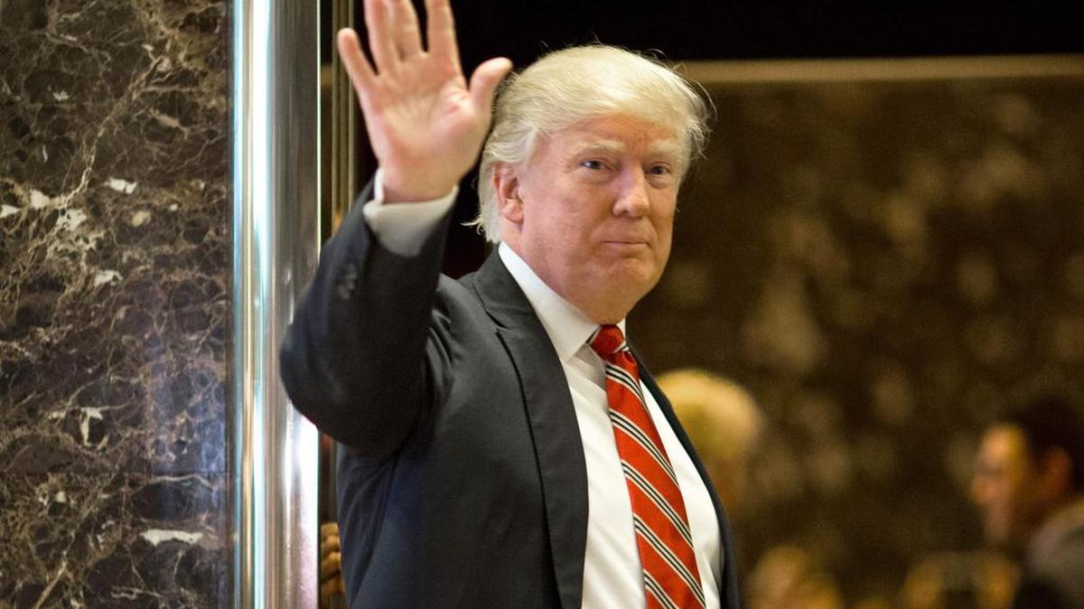 El presidente electo estadounidense Donald Trump saluda a los medios de comunicación después de reunirse con Martin Luther King III en Trump Tower en la ciudad de Nueva York el 16 de enero de 2017.