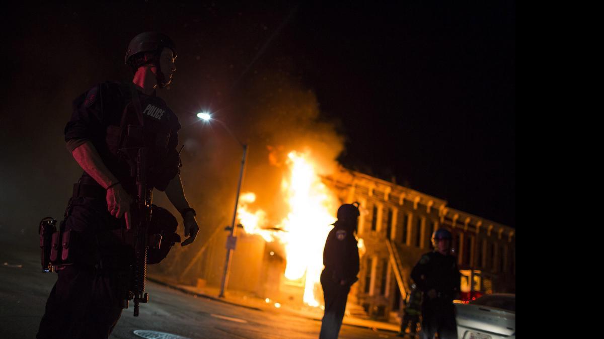 
Bomberos acuden a extinguir las llamas en un edificio durante los disturbios provocados durante una protesta contra la muerte de Freddie Gray en Baltimore (Estados Unidos) ayer, lunes 27 de abril de 2015.  
