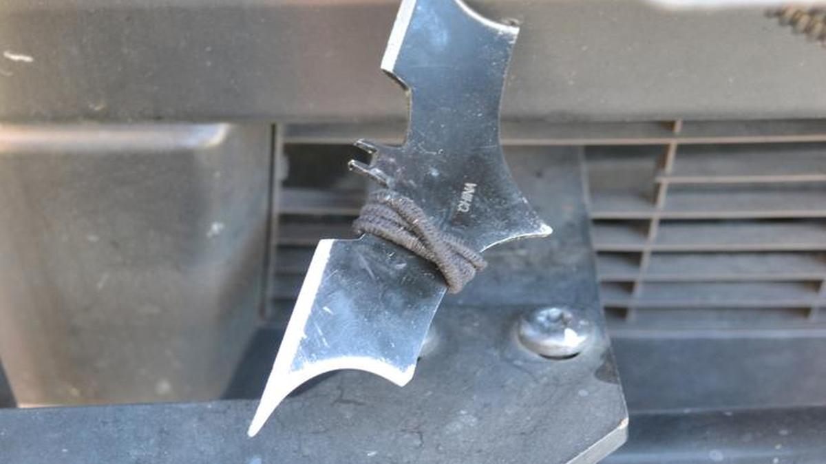 La filosa estrella ninja de Batman que arrojó el sospechoso se clavó en la parte inferior de la patrulla.