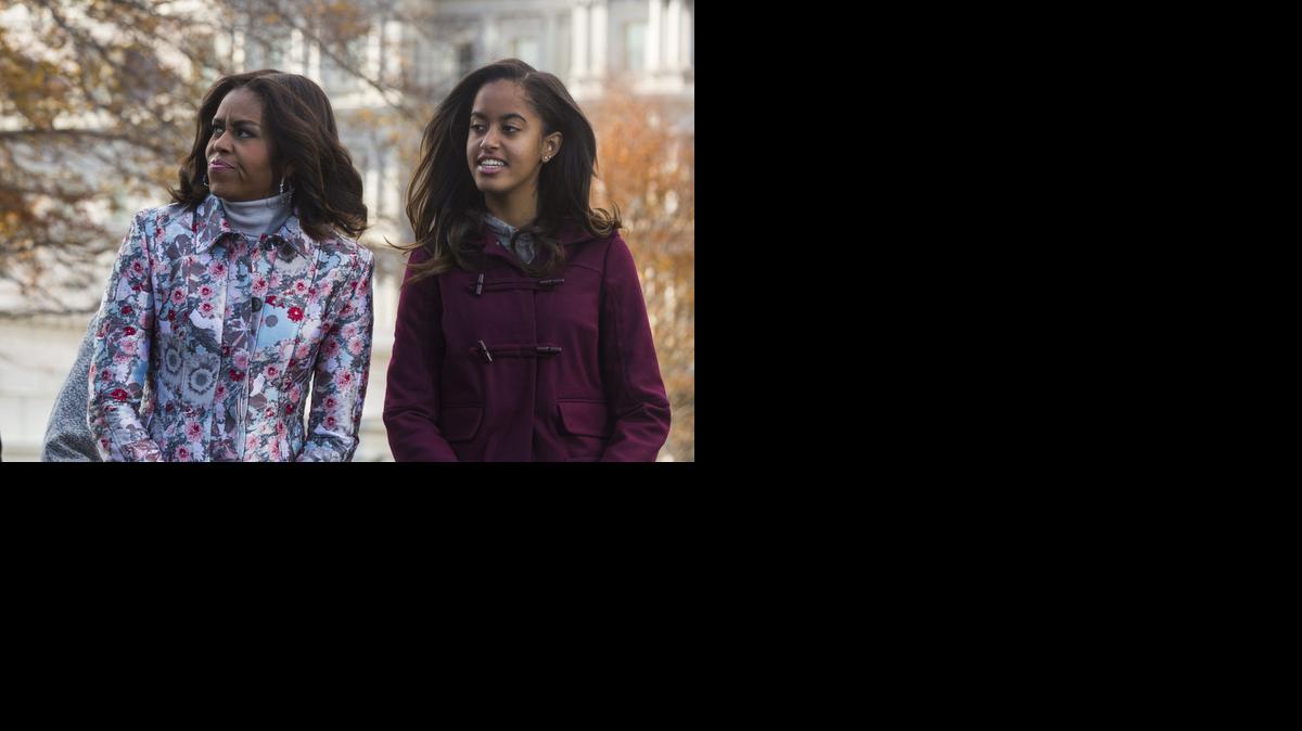 <cutline_leadin>La primera</cutline_leadin> dama estadounidense Michelle Obama (izq) y su hija Malia (der) esperan la llegada del árbol de Navidad en la fachada norte de la Casa Blanca en Washington, Estados Unidos.