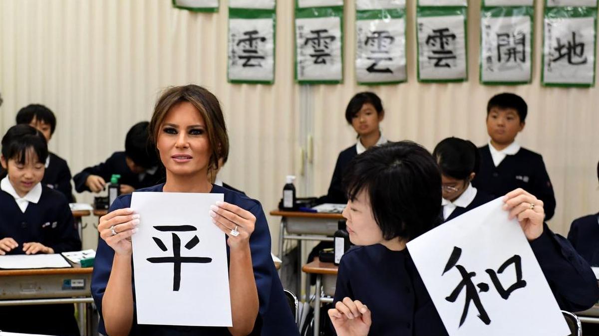 La primera dama estadounidense Melania Trump muestra su caligrafía junto a Akie Abe, esposa del primer ministro de Japón, mientras asiste a una clase de caligrafía de 4º grado en la escuela primaria Kyobashi Tsukiji en Tokio el 6 de noviembre de 2017.