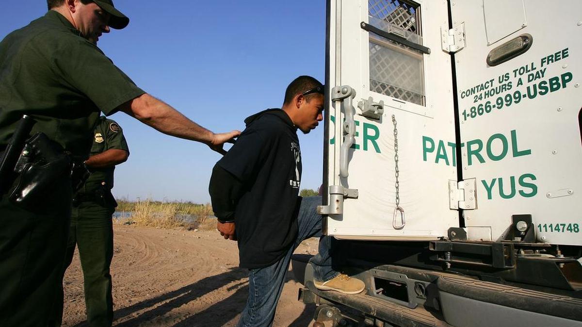 Un inmigrante indocumentado entra a un vehículo de la patrulla fronteriza de Estados Unidos después de ser detenido en la ribera del río Colorado correspondiente a California.