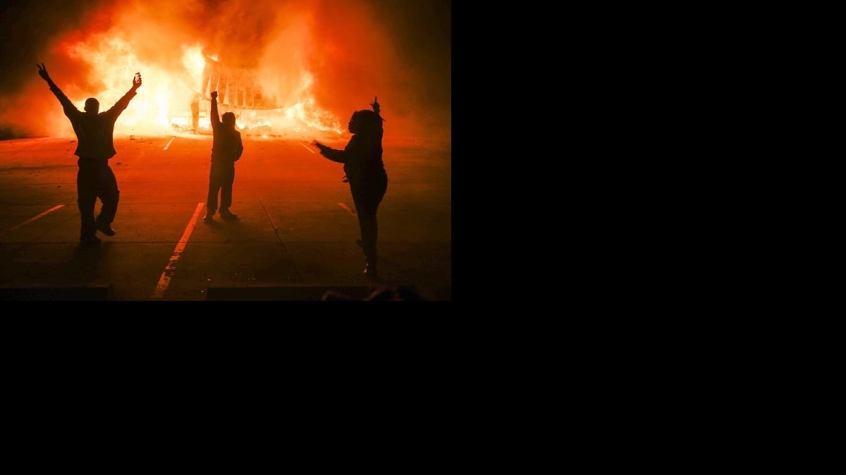 
 Manifestantes protestan ante un edificio en llamas durante los disturbios en Ferguson, Misuri, Estados Unidos, después de que el fiscal anunciara que un gran jurado había decidido no imputar al policía Darren Wilson por la muerte del joven Michael Brown ayer, lunes 24 de noviembre de 2014. EFE/Tannen Maury
