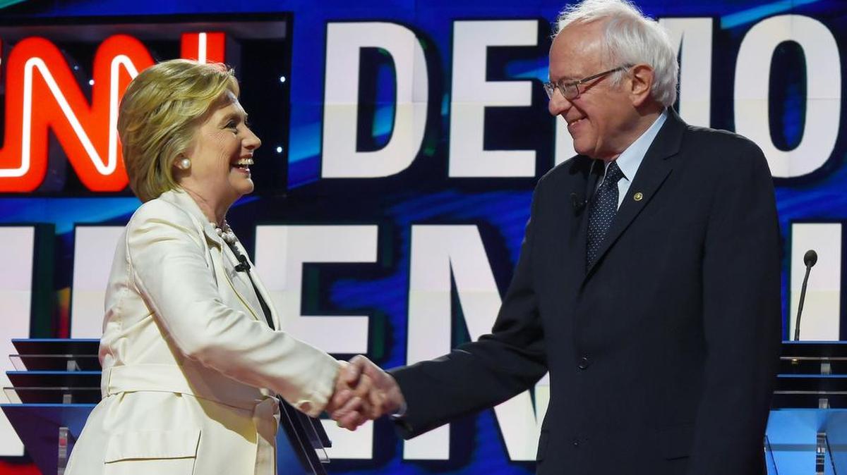 Los precandidatos presidenciales por el partido Demócrata, Hillary Clinton y Bernie Sanders, se saludan antes de iniciar el debate del jueves en Nueva York.