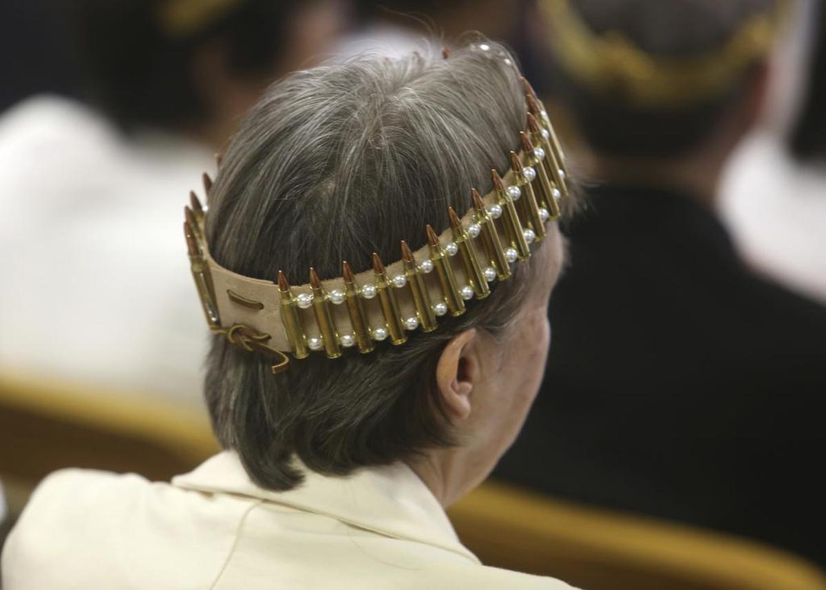 Una mujer con una corona hecha de balas durante la ceremonia del miércoles para bendecir los fusiles AR 15.