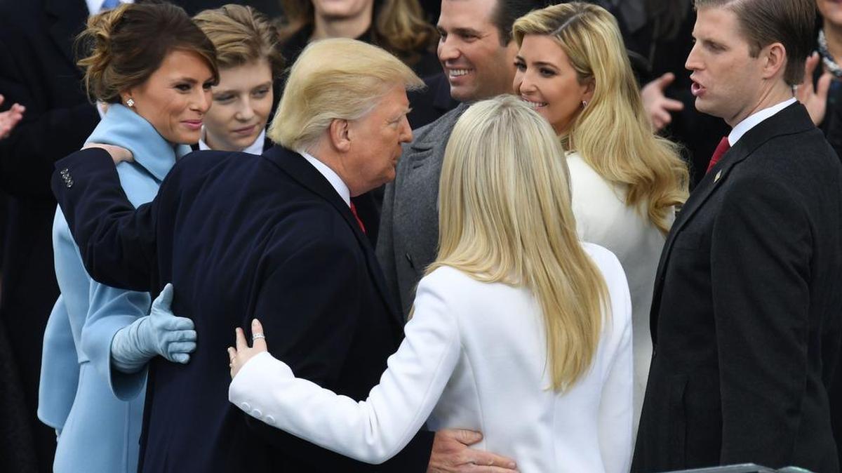 El presidente Donald Trump abraza a su familia después de prestar juramento el 20 de enero en Washington.