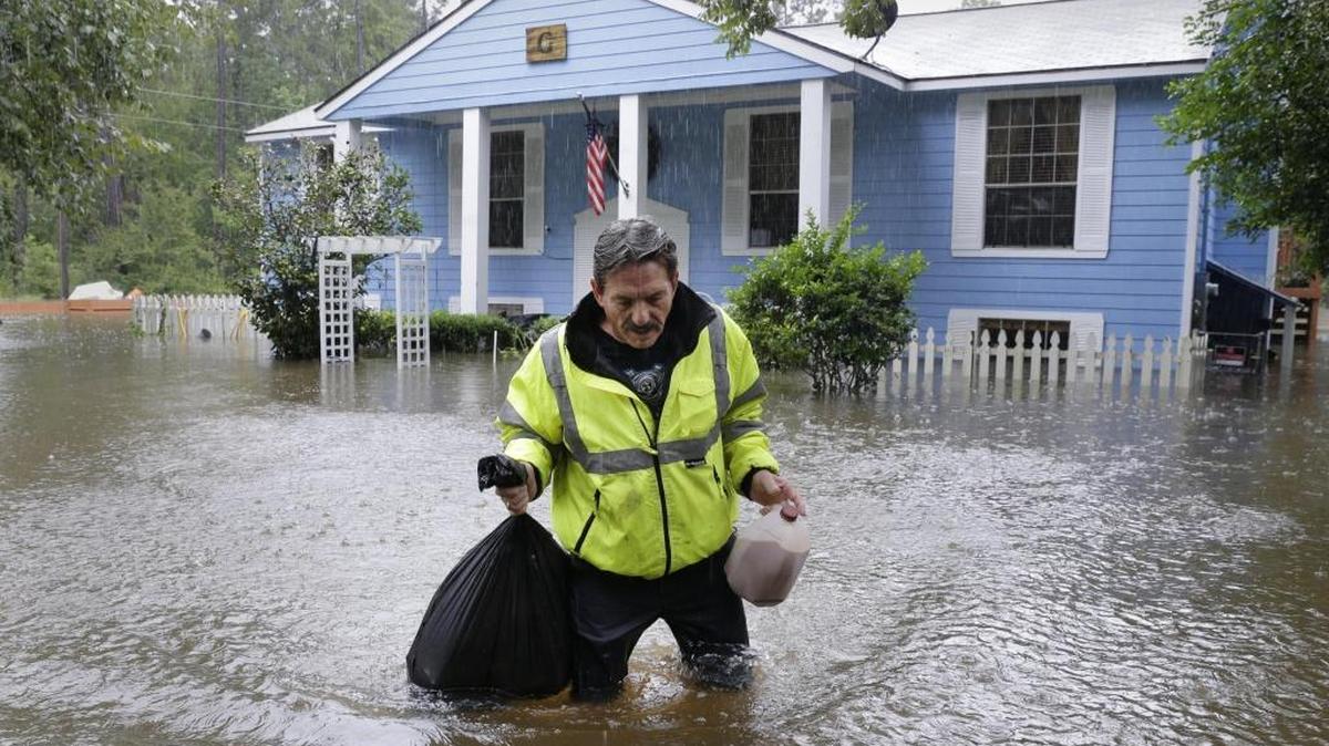 Doug Glassel camina por el agua mientras sujeta una bolsa de alimentos recuperados de su casa inundada en Spring, en el estado de Texas, en Estados Unidos, el 29 de agosto de 2017. El presidente de EEUU, Donald Trump, consideró que la tormenta Harvey ha alcanzado "proporciones épicas" y expresó su agradecimiento a los servicios de emergencia y a las autoridades locales, que se han encargado de coordinar la evacuación de 17,000 personas en el estado de Texas.