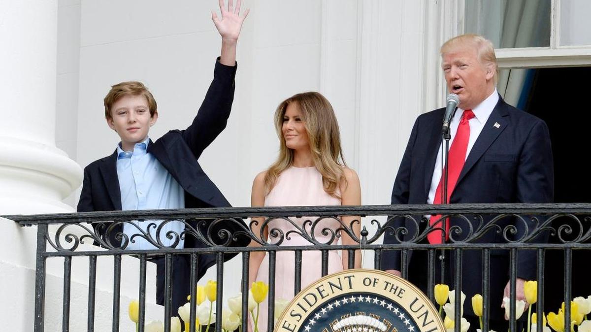 El presidente Donald Trump acompañado de su esposa, la primera dama Melania Trump (c), y su hijo Barron Trump (i), habla ante los asistentes de la tradicional búsqueda de Huevos de Pascua en los jardines del sector sur de la Casa Blanca en Washington (EE.UU.).