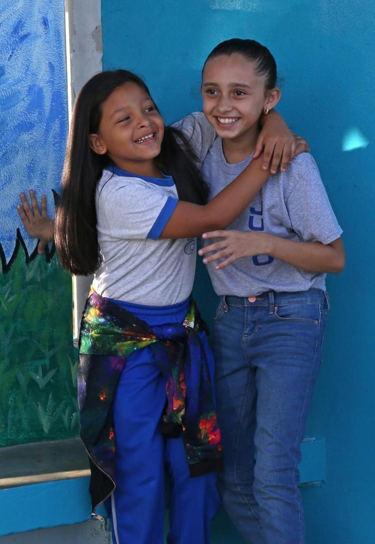 Annyelys (izq) abraza a Krystal, su compañera de cuarto grado, en el reinicio de las clases en la escuela Julio Selles Solá de Río Piedras, Puerto Rico, que fue cerrada tras el paso del huracán María.