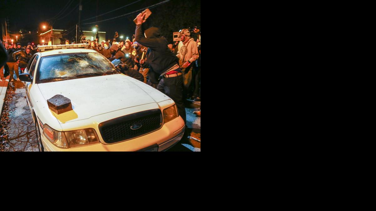 
Manifestantes destrozan un coche policial en Ferguson, Missouri, durante los disturbios tras la decisión de un gran jurado de no procesar al policía Darren Wilson por matar a Michael Brown en esa ciudad.
