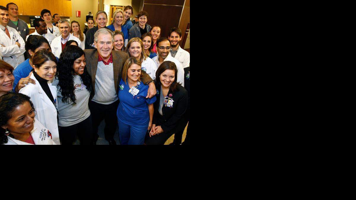 
El ex president George W. Bush posa con los trabajadores sanitarios de la unidad de cuidados intensivos del Texas Health Presbyterian Hospital, este viernes, in Dallas.
