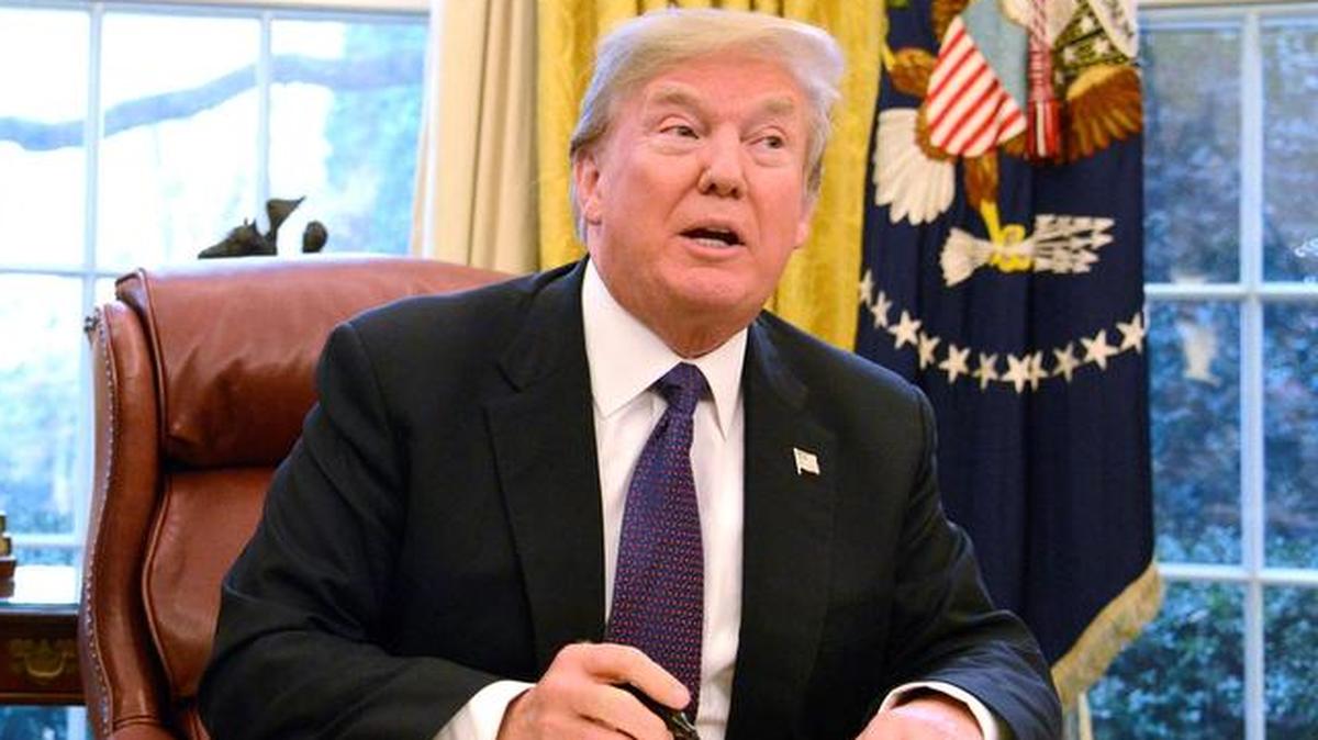 El presidente de los Estados Unidos, Donald J. Trump, estampa su firma en la normativa que da validez a la imposición de aranceles sobre las importaciones de placas y células solares y lavadoras residenciales en el Despacho Oval de La Casa Blanca, Washington, DC el 23 de enero de 2018.