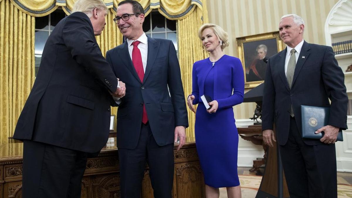 El presidente de EE.UU. Donald J. Trump (i), felicita al nuevo secretario del Tesoro Steven Mnuchin (2-i) junto a la prometida de Mnuchin, Louise Linton (2-d), y el vice presidente EE.UU. Mike Pence (d), durante la toma de juramento de Mnunchin el lunes 13 de febrero de 2017, en la Oficina Oval de la Casa Blanca en Washington.
