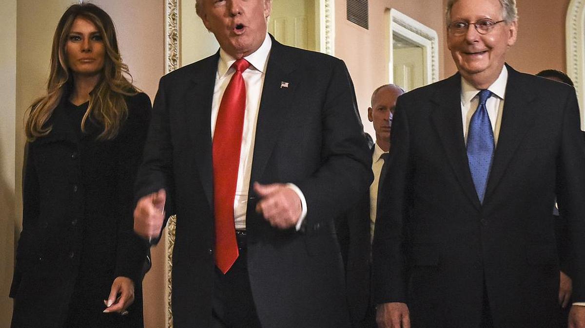 El presidente Donald Trump camina en una foto de archivo en el Capitolio de EEUU junto a su esposa Melania, y el senador Mitch McConnell.