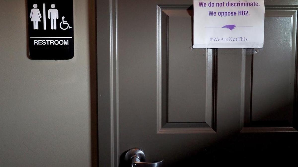 Un cartel de "No somos Esto" en las afueras de un baño unisex en Bull McCabes Irish Pub el 10 de mayo de 2016, Durham, Carolina del Norte.