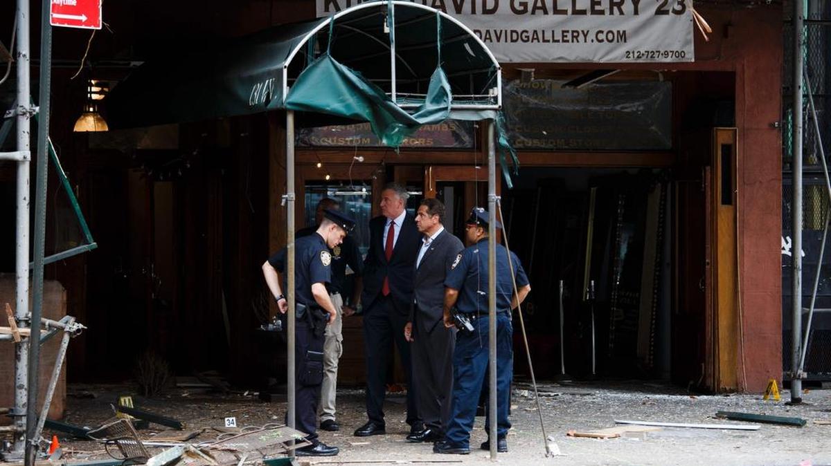El gobernador de Nueva York, Andrew Cuomo (2do-der.) y el alcade de la ciudad de Nueva York (3ro-der.) se presentan en el lugar donde ocurrió una explosión que causó 29 heridos.