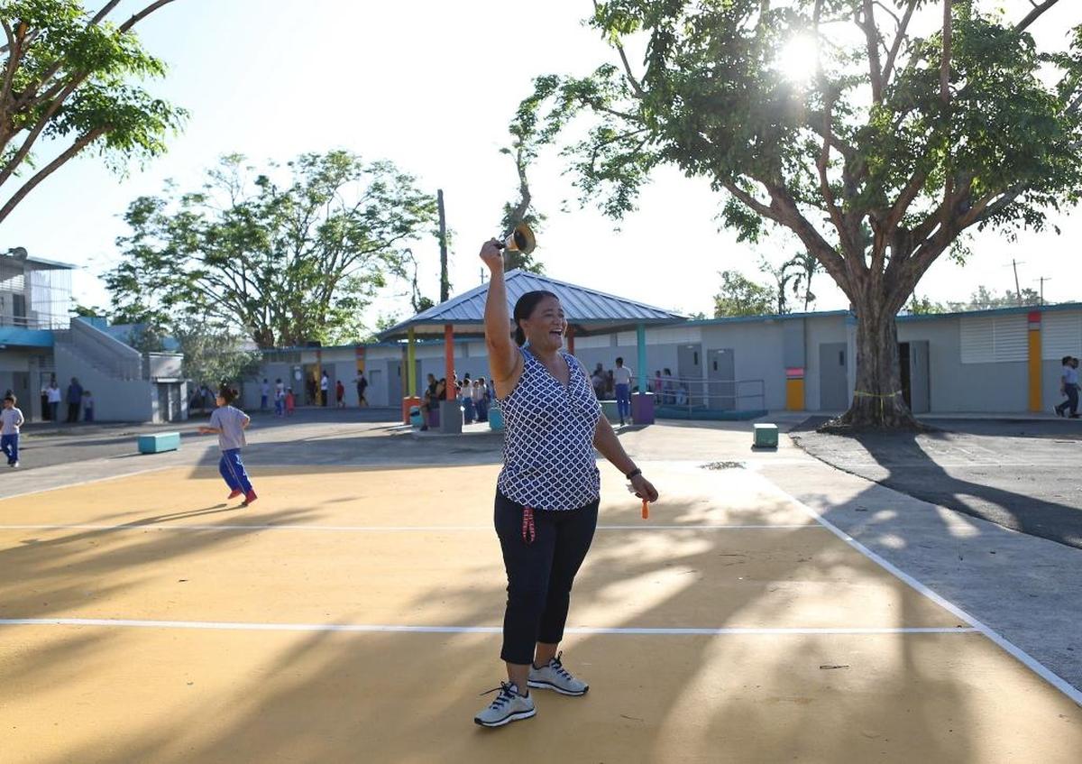 Iris García, empleada de mantenimiento, hace sonar la campana en la escuela primaria Julio Selles Solá, en Río Piedras, Puerto Rico.