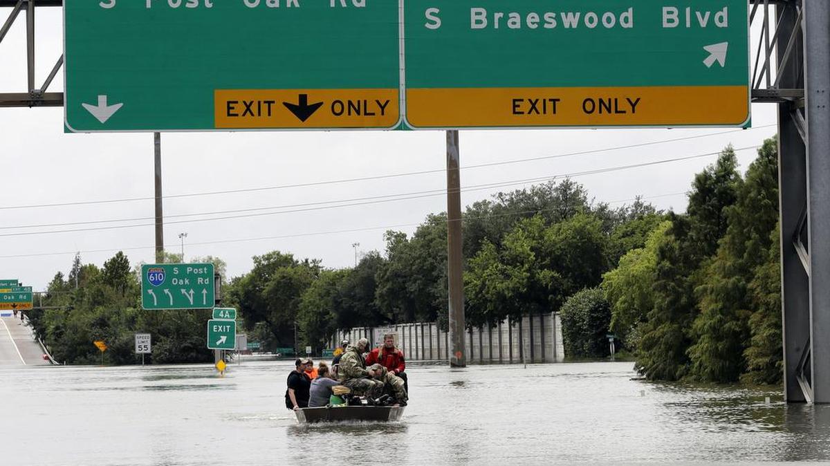 Residentes son rescatados de sus hogares rodeados por las inundaciones de la tormenta tropical Harvey el domingo, 27 de agosto de 2017, en Houston, Texas.