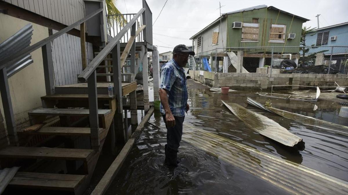 Héctor Rosa, residente del sector Juana Matos, camina por un área completamente inundada después del paso del huracán María por Puerto Rico.