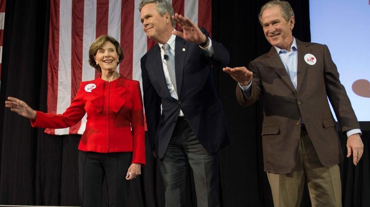 El ex presidente George W. Bush (der.), junto a su esposa Laura y Jeb Bush, saluda el lunes a sus seguidores durante un evento de campaña en Carolina del Sur.