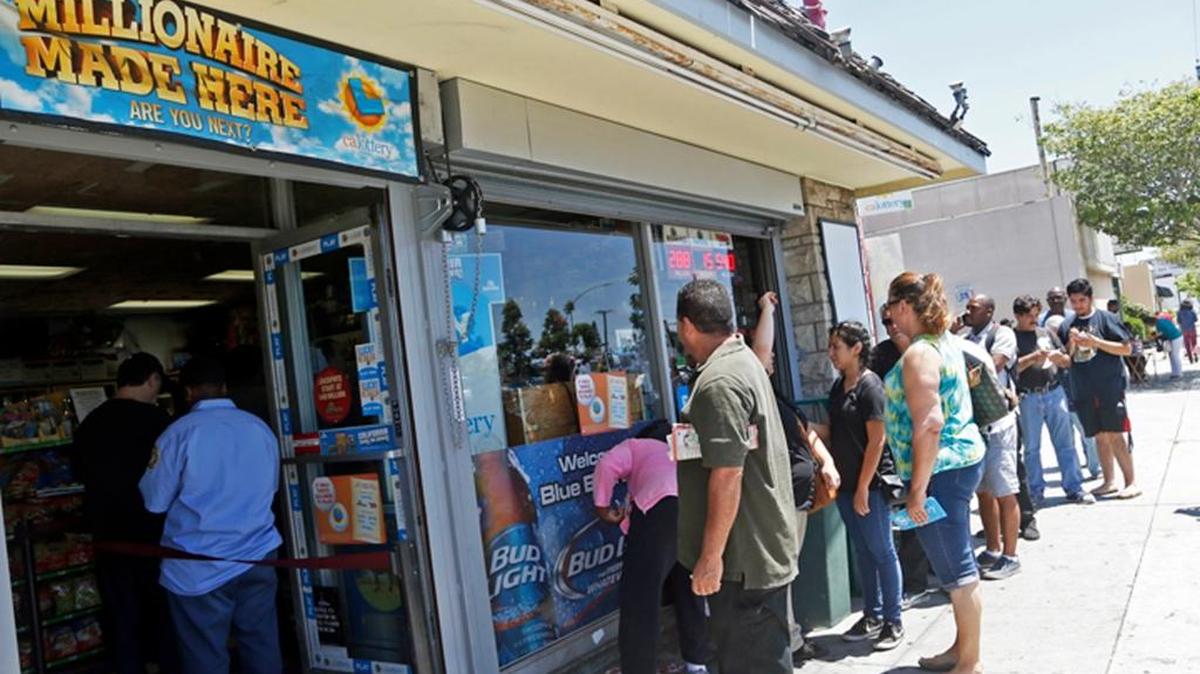 Docenas de personas en fila para comprar los boletos de la loteria Mega Millions.