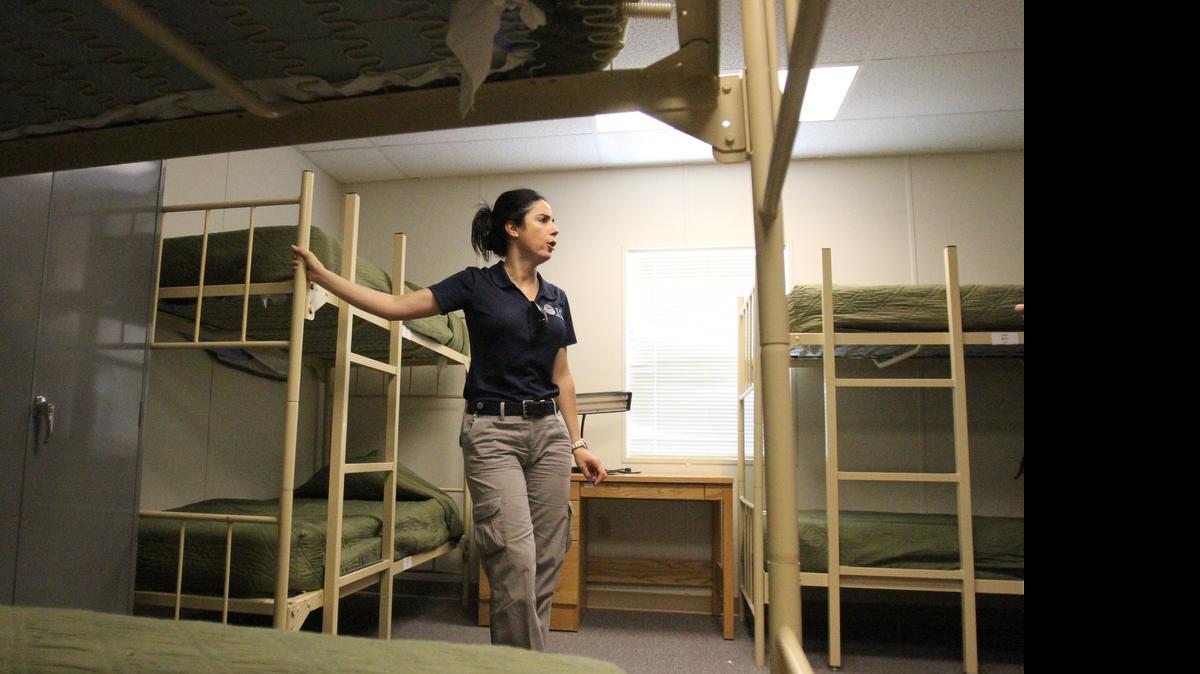 
Una funcionaria de inmigración muestra un dormitorio para familias de indocumentados en un centro de detención en Nuevo México.
