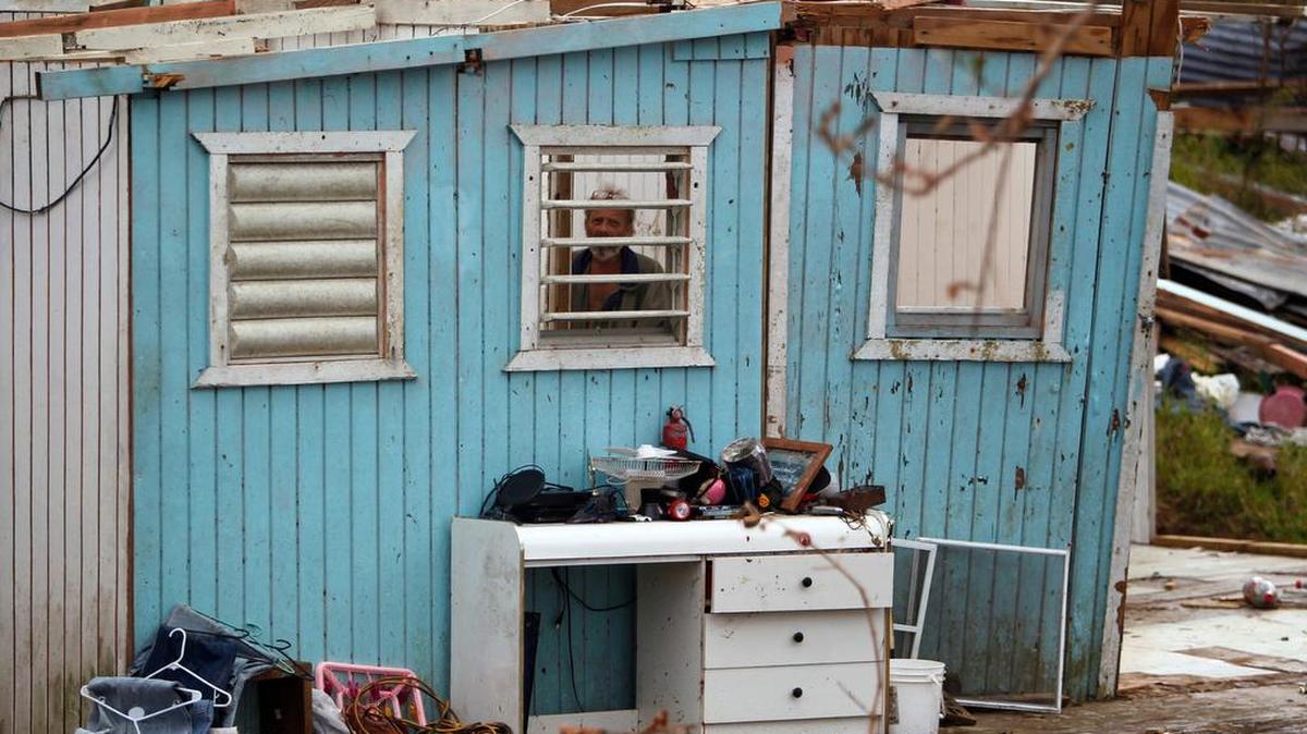 El Germán Rodríguez mira a través de una ventana desde su casa destruida tras el huracán María, en Aibonito, Puerto Rico, el 29 de septiembre de 2017.