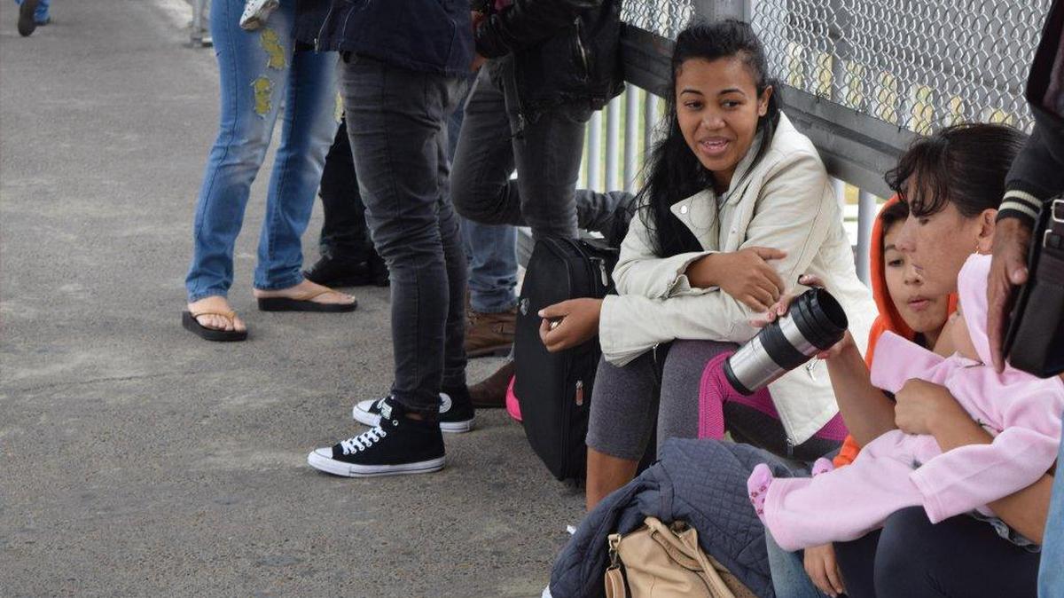 La cubana Irina Vicardo (d), madre de dos niños de 8 años y 1 año, espera sentada a escasos metros de territorio estadounidense mientras cubanos se manifiestan de forma pacífica formando una fila en la puerta de entrada a Estados Unidos en Laredo (Texas, EE.UU) este domingo 15 de enero de 2017, en Laredo, Texas, EEUU.