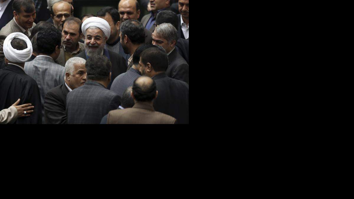 
El presidente de Irán Hassan Rouhani, centro, rodeado por un grupo de legisladores en la sede del Parlamento en Teherán.


