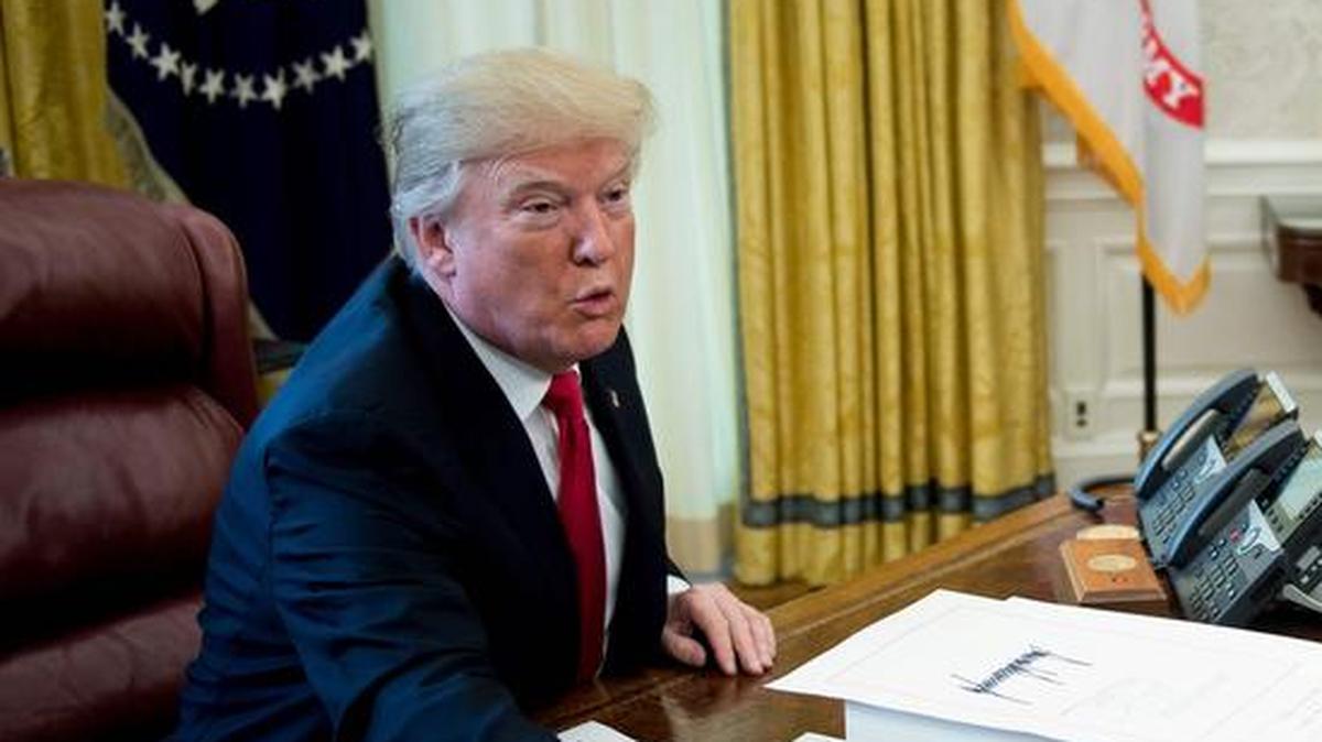 El presidente de EEUU, Donald Trump, ofrece bolígrafos a la prensa después de firmar un proyecto de reforma fiscal en la Oficina Oval de la Casa Blanca el 22 de diciembre de 2017 en Washington, DC.
