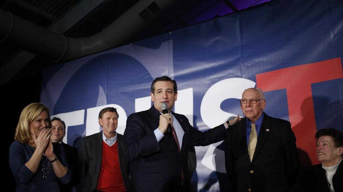El senador Ted Cruz, republicano de Texas que busca la presidencia, toca el hombro de su padre Rafael Cruz, de pie junto a su madre Eleanor Darragh. La esposa de Ted Cruz, Heidi Cruz, está a la izquierda.